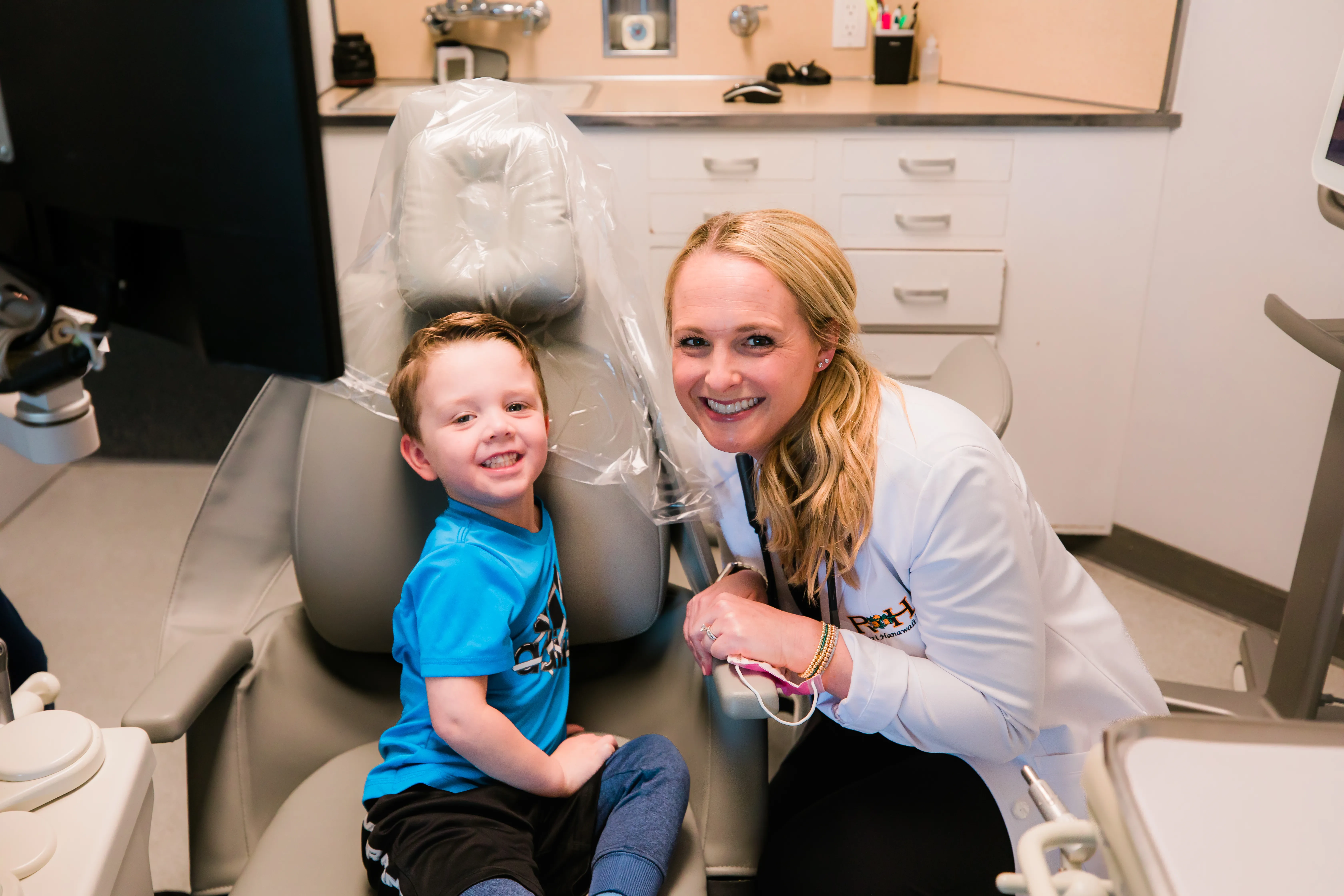 Child smiling during gentle dental examination with pediatric dentist